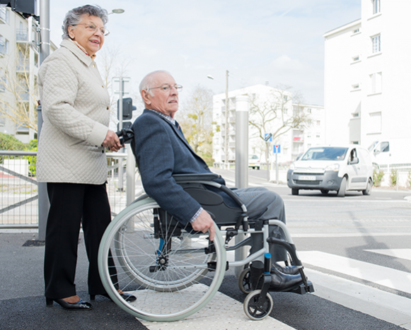 woman pushing man in wheel chair