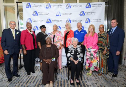 Group of adults posing in front of a step and repeat